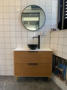 ארון אמבטיה בצבע חום עם ידיות שחורות כיור ברז ומראה שחורה