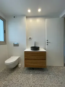 ארון אמבטיה בצבע חום רצפה עם נקודות שחורות כיור שחור מט וברז כסוף