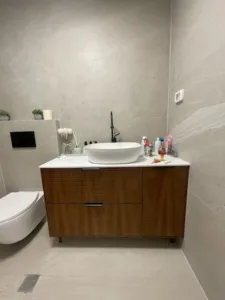 ארון אמבטיה בצבע חום עם קיר אפור