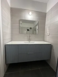 ארון אמבטיה בצבע כחול עם ידיות בכסף קיר בצבע סגול בהיר