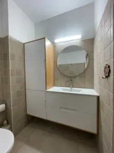 ארון אמבטיה בצבע לבן ועץ וכיור עם מראה עגולה